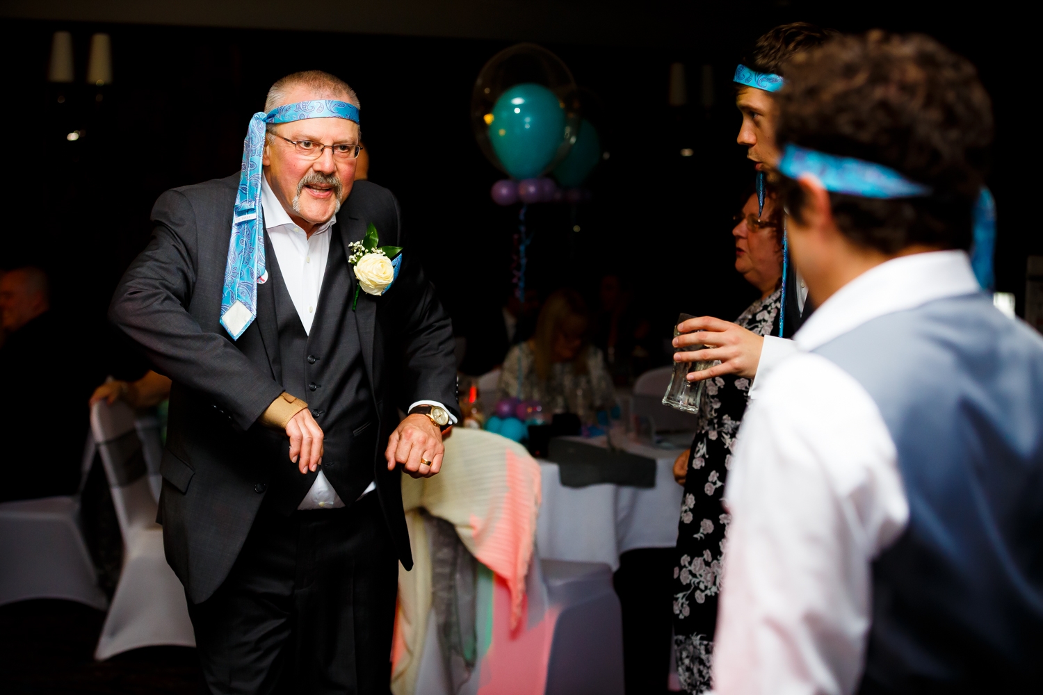 Grooms dad dancing with a tie around his head