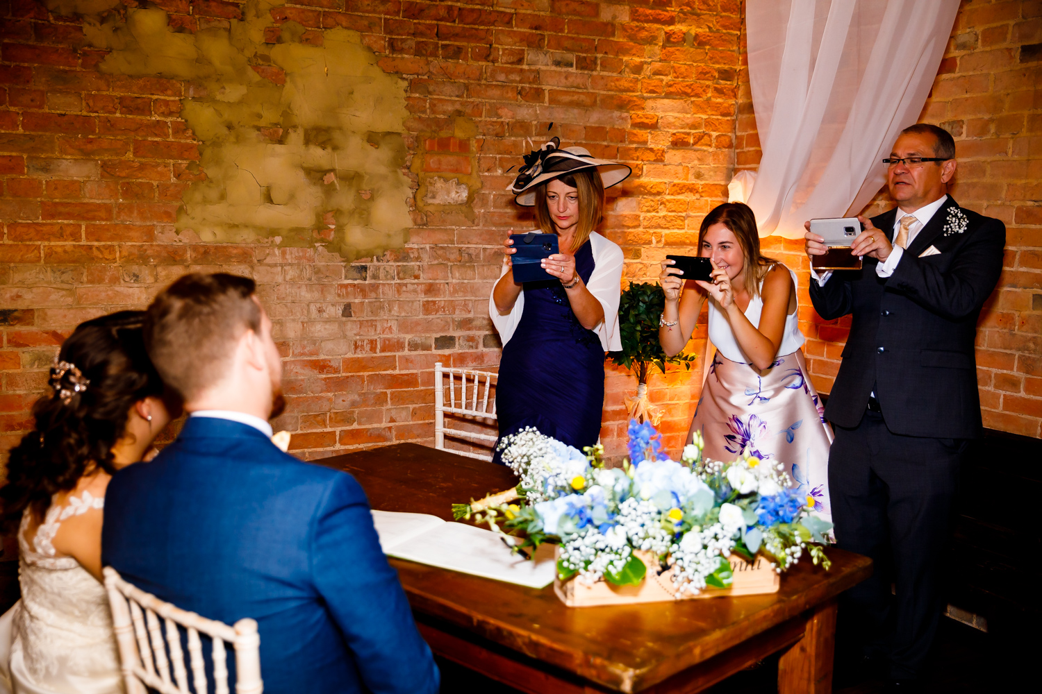 Guests taking the bridge and grooms photos whilst signing the register