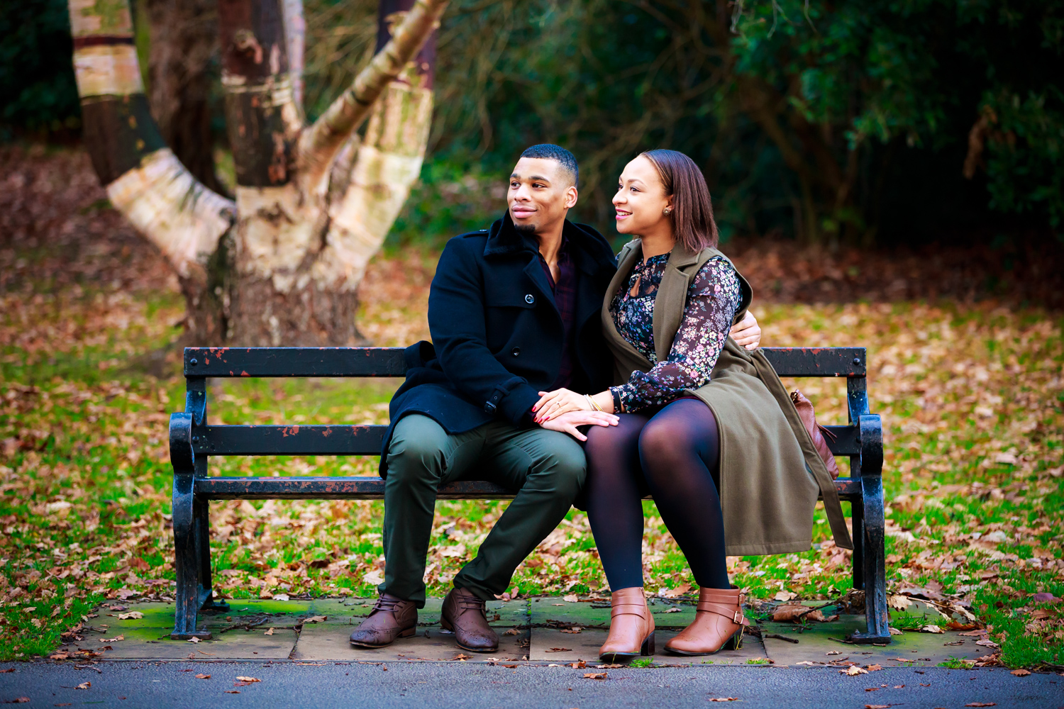 Couple sitting on  a bench in Brueton Park during their engagement shoot