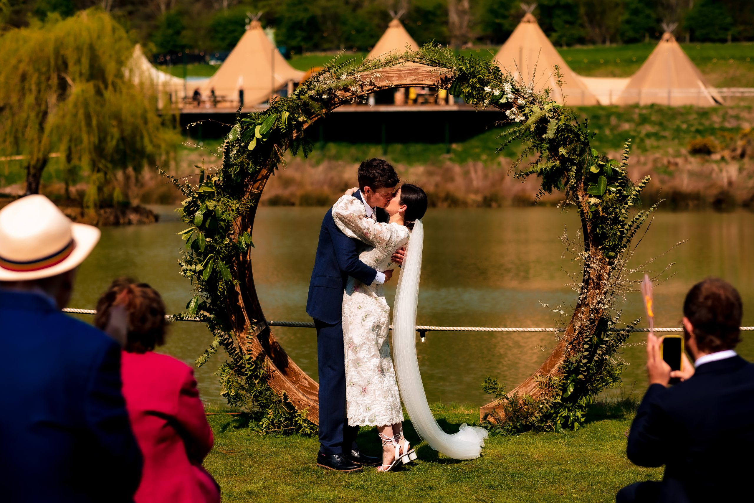 0W1A4633 Bride and groom walking hand in hand along a wooden boardwalk