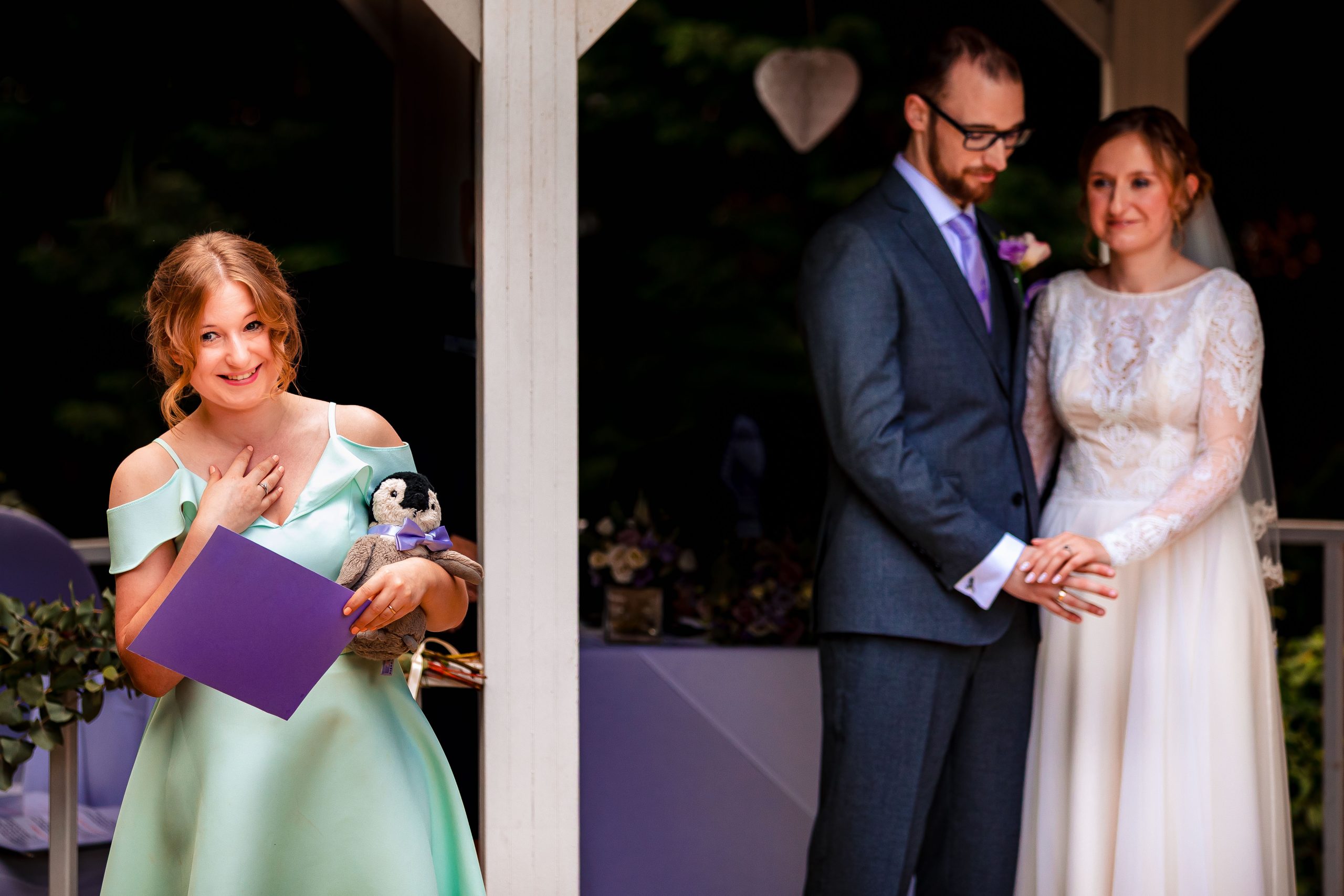 The maid of honour giving a wedding ceremony reading whilst holding her penguin teddy
